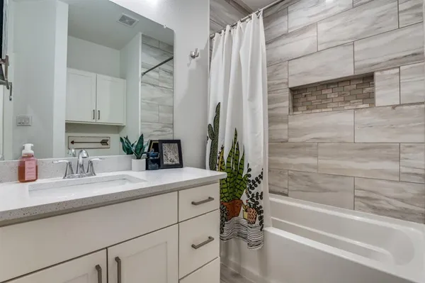 a bathroom with a granite countertop sink a toilet and bathtub
