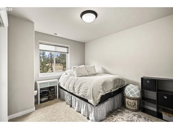 a bedroom with a bed and a dresser next to a window
