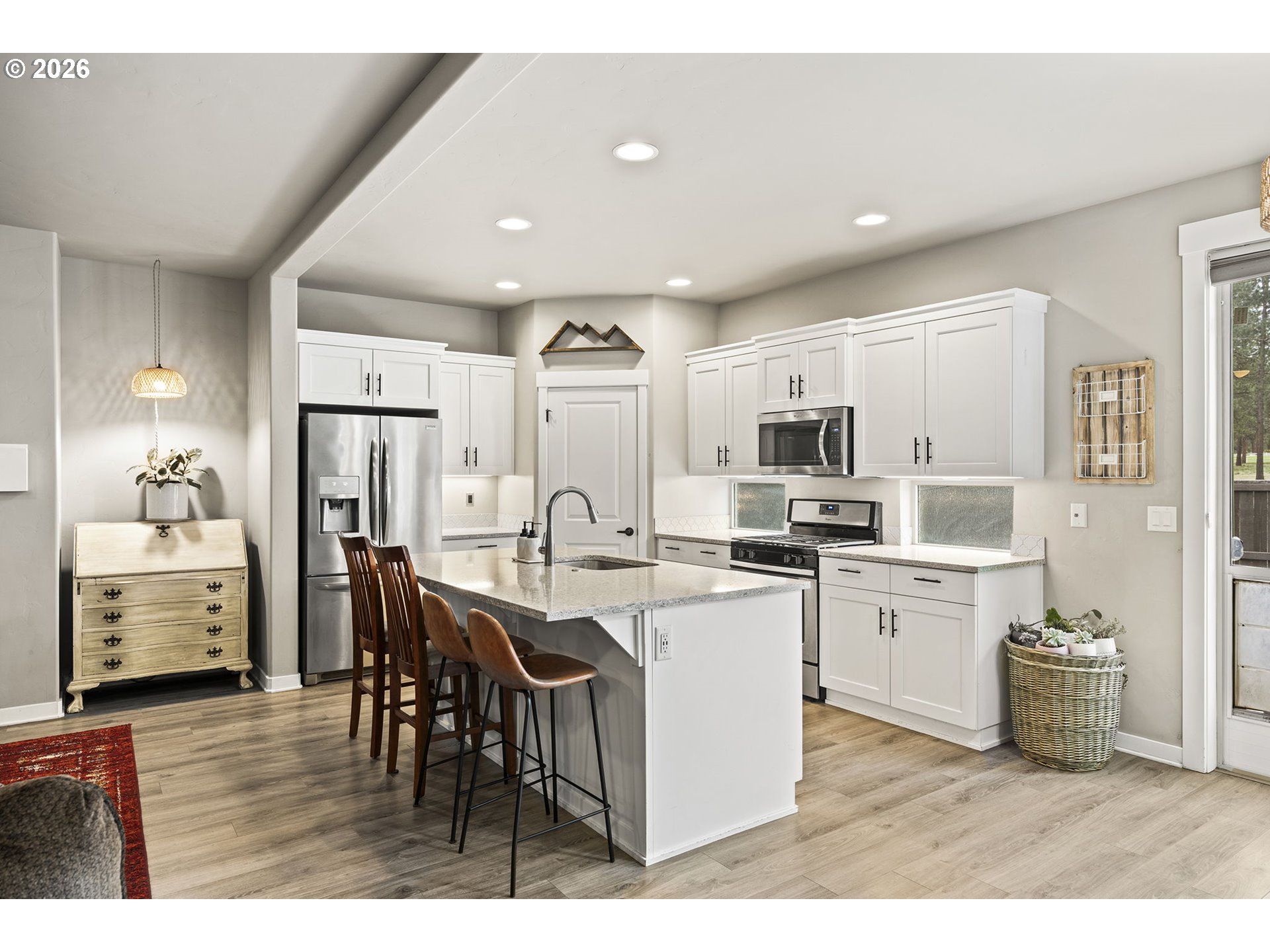 60439 Hedgewood Lane Bend, OR 97702 - Photo 3 of 44 a open kitchen with stainless steel appliances kitchen island granite countertop a refrigerator a stove a sink a dining table and chairs