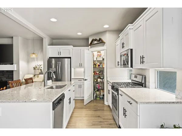 a kitchen with granite countertop a sink stove and refrigerator