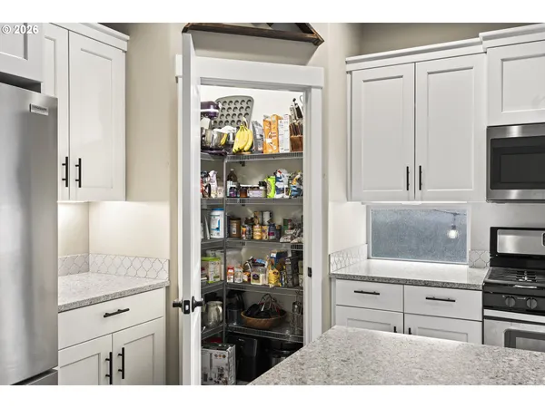 a kitchen with white cabinets and appliances
