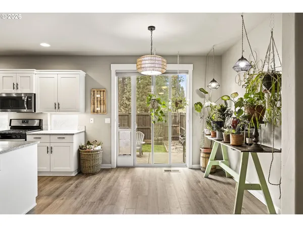 a open kitchen with granite countertop a stove a sink dishwasher and a refrigerator with wooden floor
