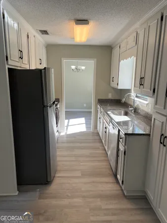 a kitchen with stainless steel appliances granite countertop a refrigerator and a sink