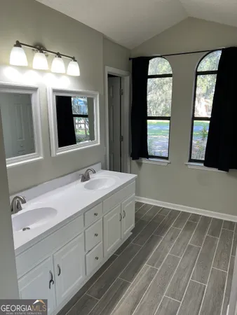 a bathroom with double vanity sink and mirror