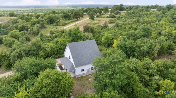 an aerial view of a house with a yard and trees