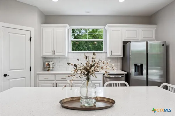 a kitchen with a table and a refrigerator
