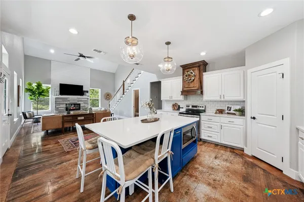 a large kitchen with a table and chairs in it