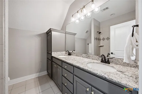 a bathroom with a granite countertop sink and a mirror