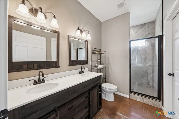 a bathroom with a double vanity sink mirror and toilet
