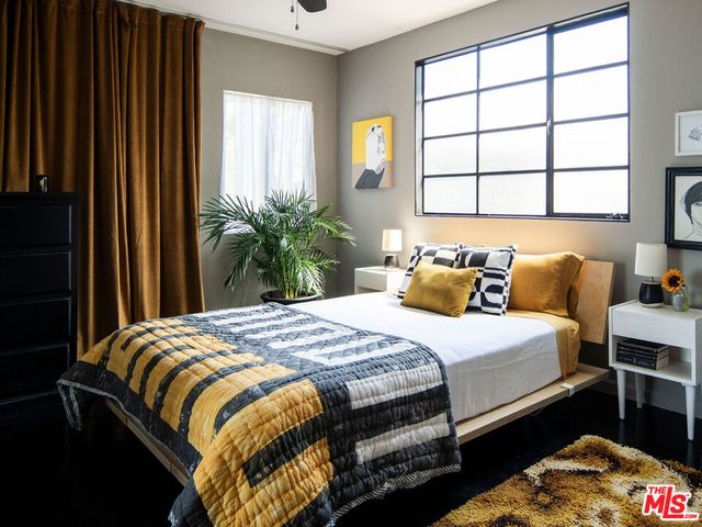 a bedroom with a bed and a potted plant