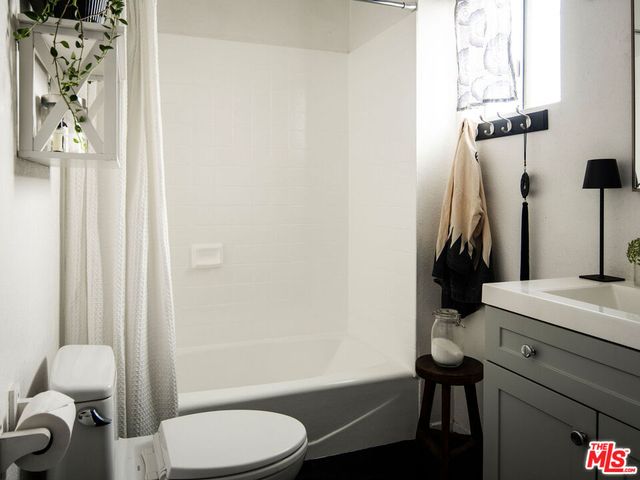a bathroom with a toilet and a shower curtain