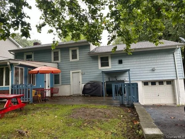 a backyard of a house with yard table and chairs under an umbrella