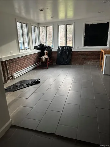 a living room with furniture a flat screen tv and a window