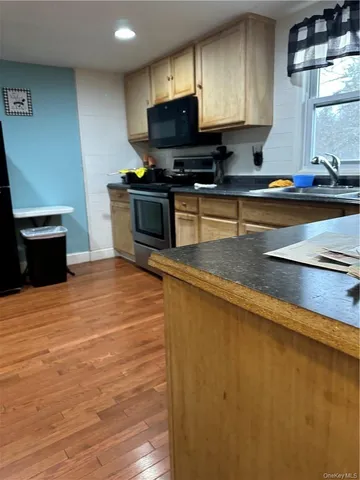 a kitchen with stainless steel appliances a stove a sink and a microwave