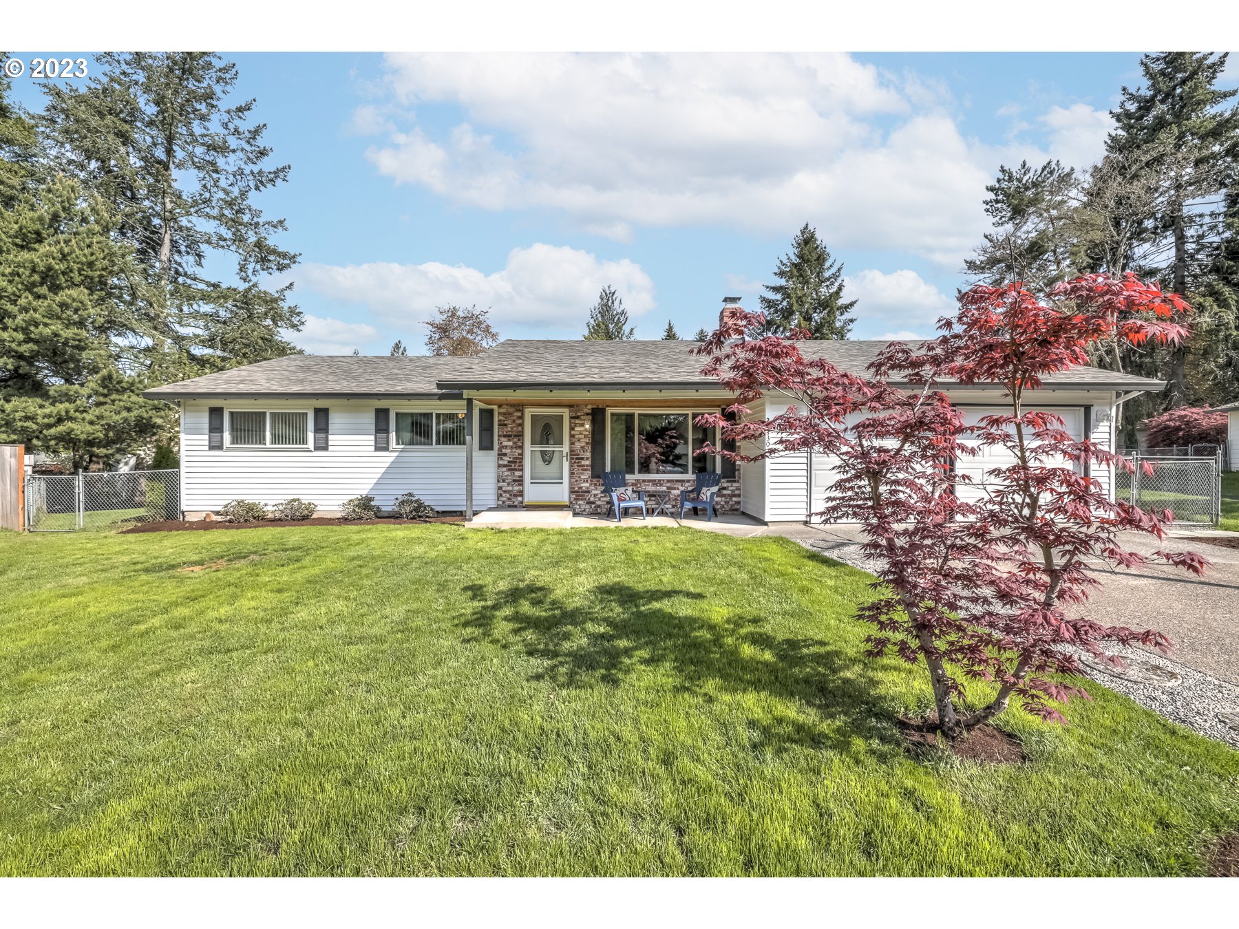 a view of a house with a garden and trees
