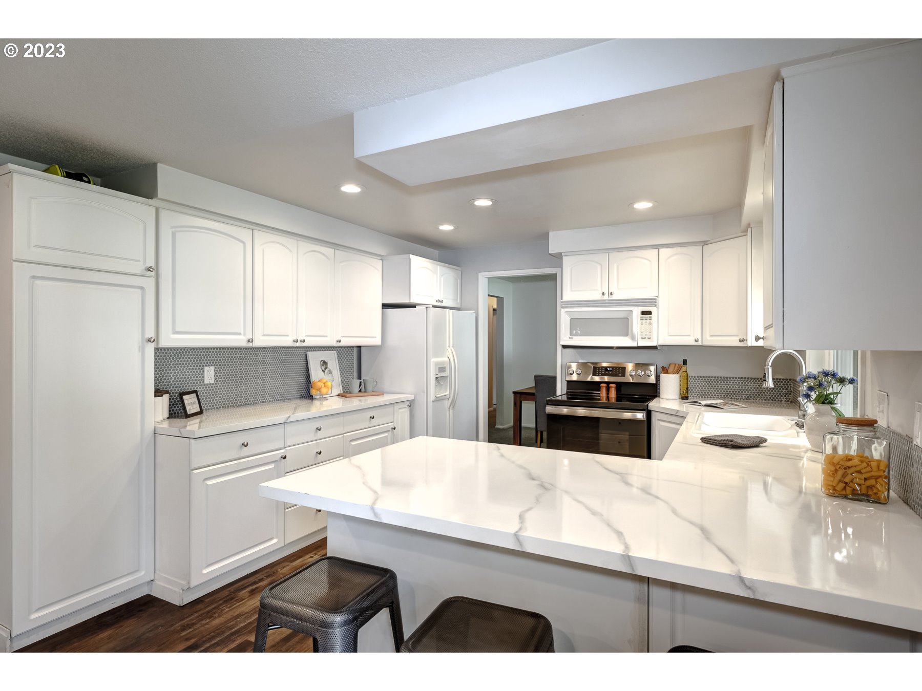20430 Southwest Avon Court Beaverton, OR 97078 - Photo 14 of 29 a kitchen with a sink a stove a refrigerator and white cabinets