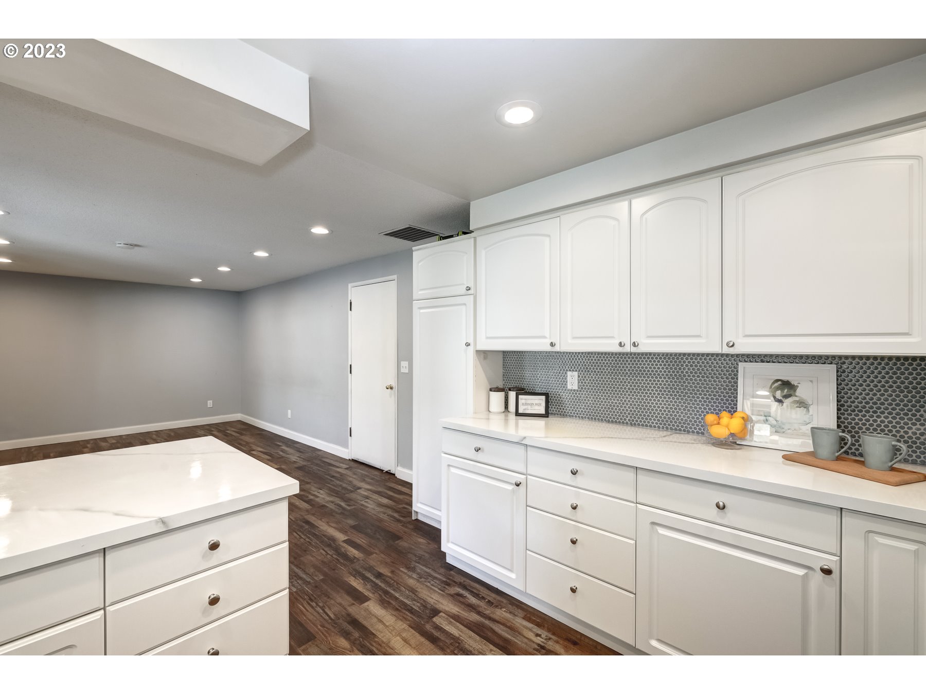 20430 Southwest Avon Court Beaverton, OR 97078 - Photo 15 of 29 a kitchen with a sink dishwasher and white cabinets with wooden floor