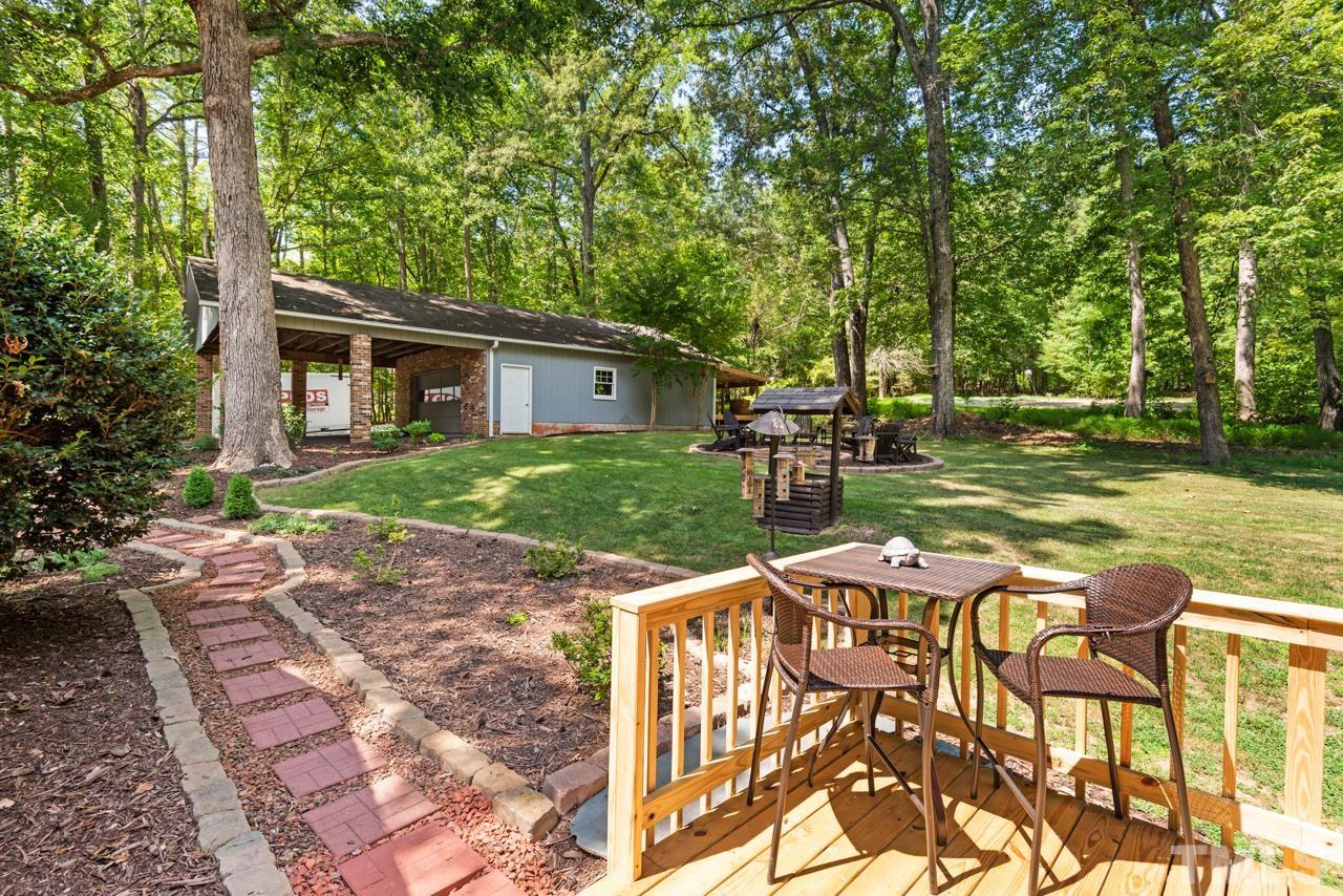 8201 Bromley Road Hillsborough, NC 27278 - Photo 49 of 77 a view of a patio with table and chairs and potted plants with large trees
