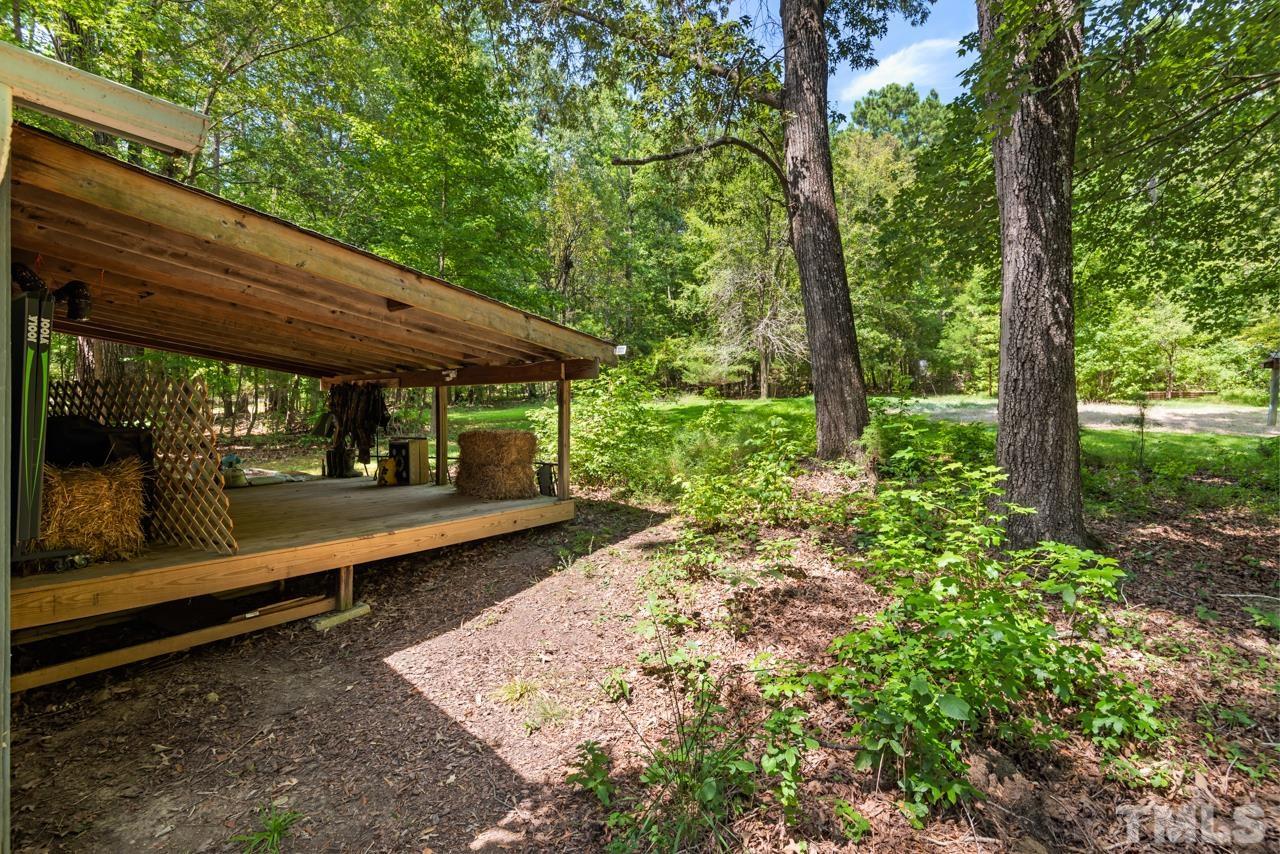 8201 Bromley Road Hillsborough, NC 27278 - Photo 57 of 77 a view of a patio with table and chairs under an umbrella with a large tree