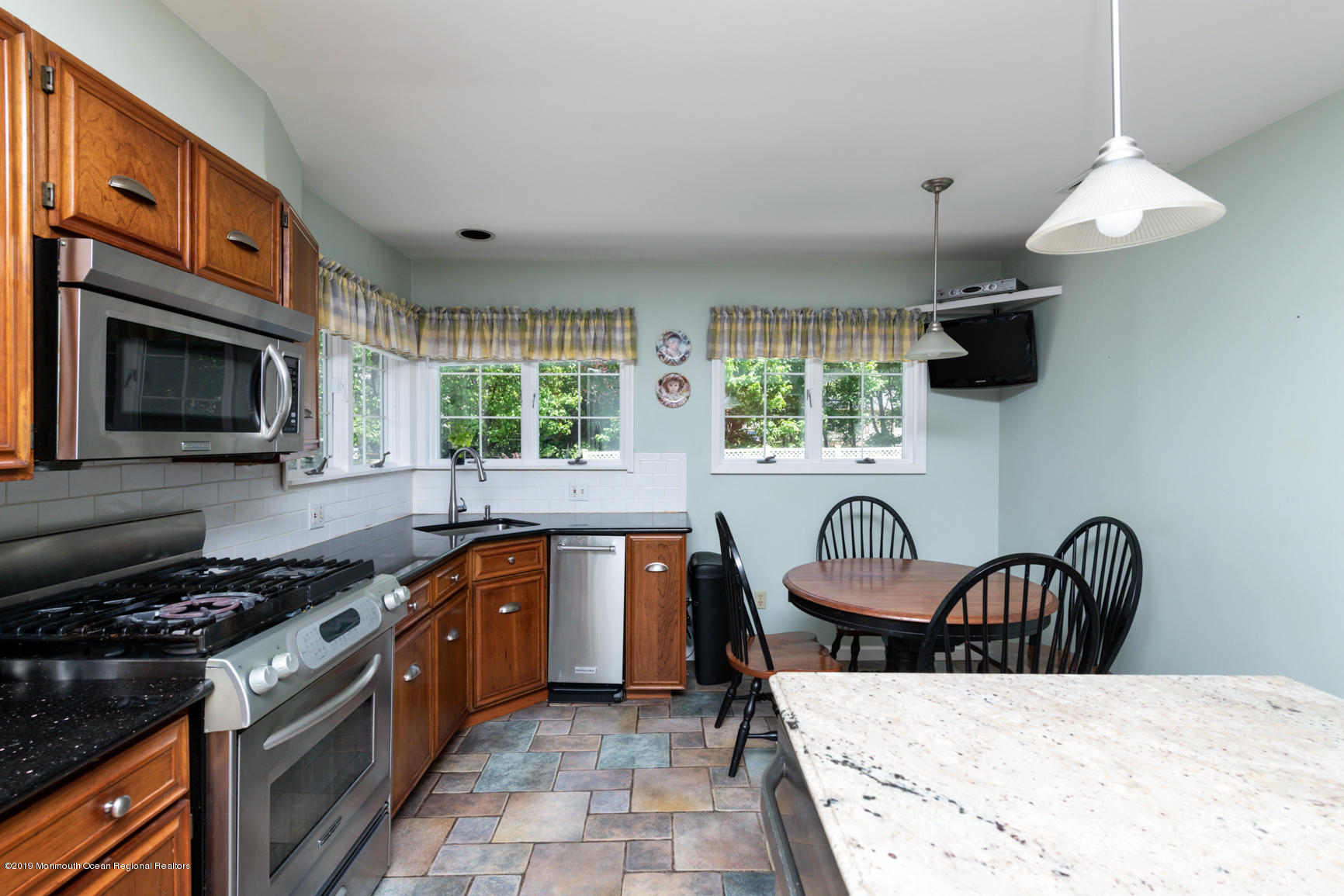 10 Gull Road Middletown, NJ 07748 - Photo 11 of 18 a kitchen with stainless steel appliances granite countertop a stove top oven a sink a dining table and chairs
