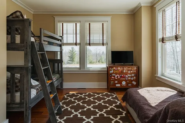 a bedroom with a bed and a flat tv screen on dresser