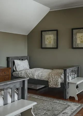a bedroom with two beds and wooden floor