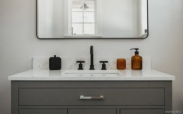 a bathroom with a sink vanity and mirror