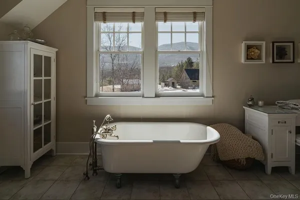 a white bath tub sitting in a bathroom next to a window