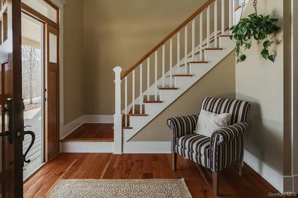 a view of entryway and hall with wooden floor