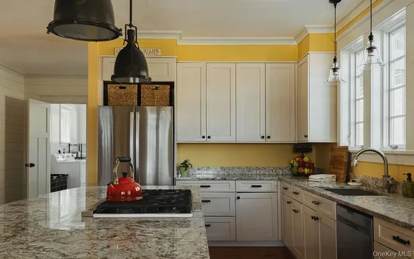 a kitchen with stainless steel appliances a stove a sink a refrigerator and cabinets