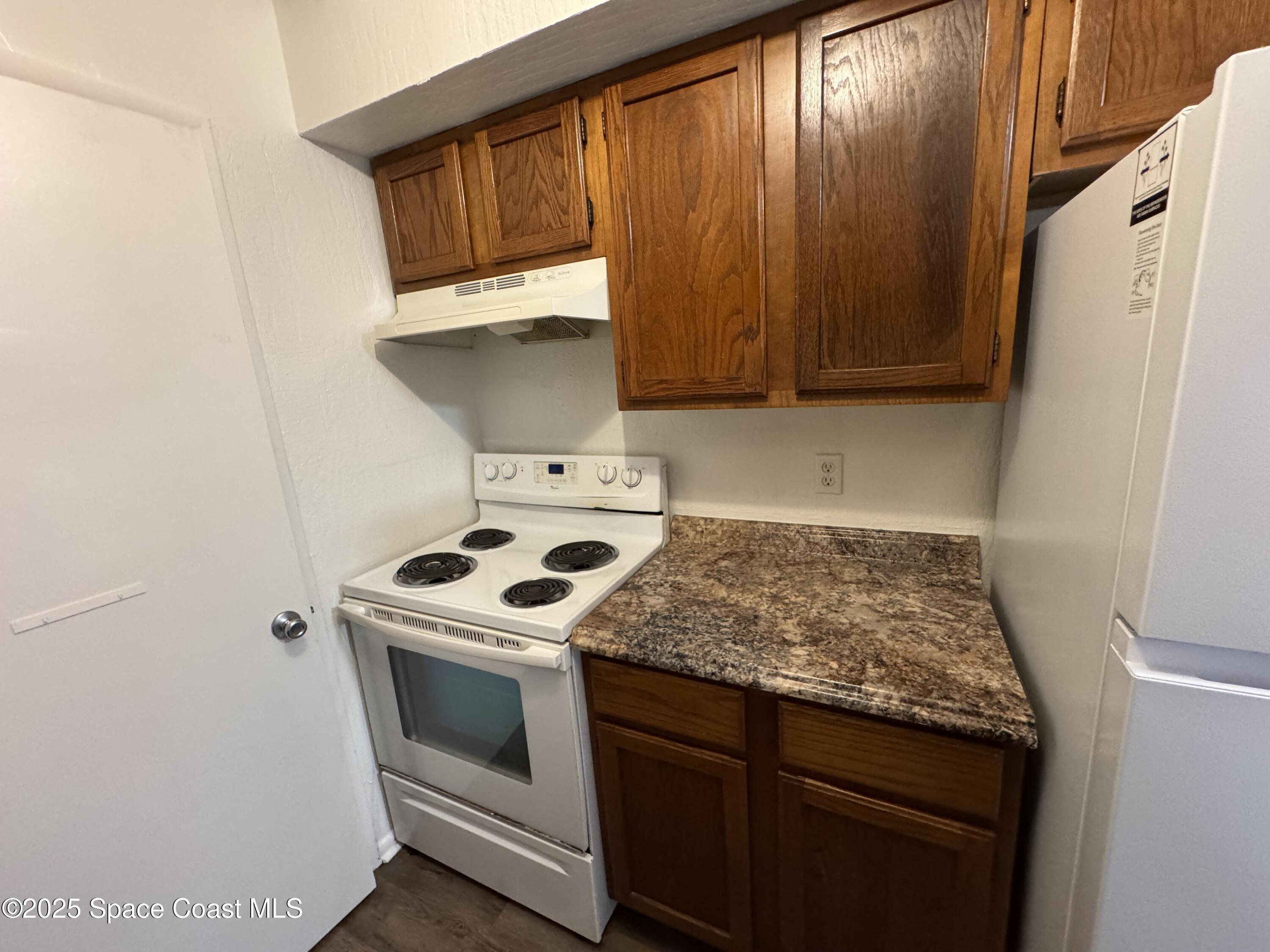 2130 Forest Knoll Drive Northeast, Unit 30208 Palm Bay, FL 32905 - Photo 14 of 19 a kitchen with a stove and a cabinet