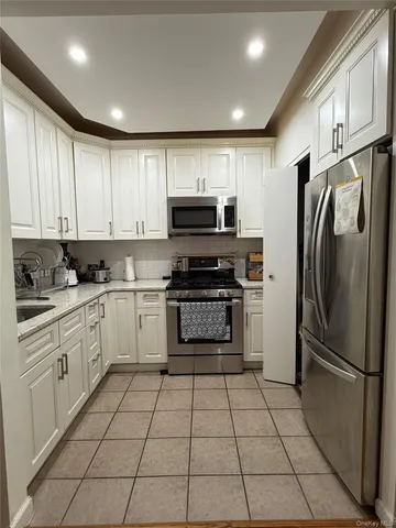 a kitchen with granite countertop a refrigerator and a stove top oven
