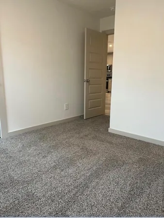 en empty room with windows and chandelier fan