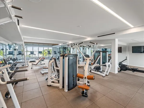 a living room with furniture a flat screen tv and a floor to ceiling window