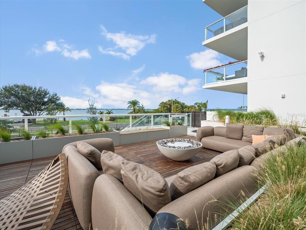 1020 Sunset Point Road, Unit 511 Clearwater, FL 33755 - Photo 58 of 93 a view of a patio with couches chairs and a yard
