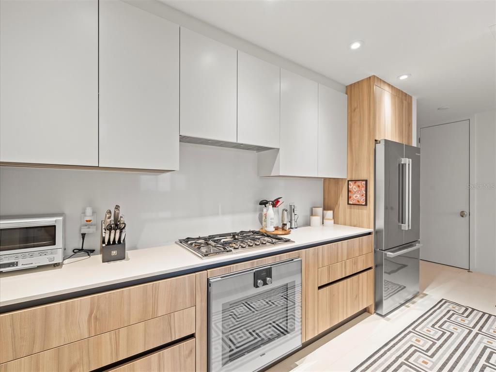 1020 Sunset Point Road, Unit 511 Clearwater, FL 33755 - Photo 62 of 93 a kitchen with stainless steel appliances granite countertop a sink stove refrigerator and cabinets