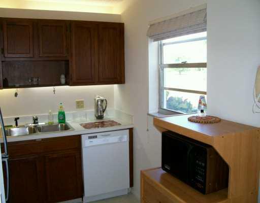 1225 Northwest 21st Street, Unit 3105 Stuart, FL 34994 - Photo 4 of 8 a kitchen with a sink stove and cabinets