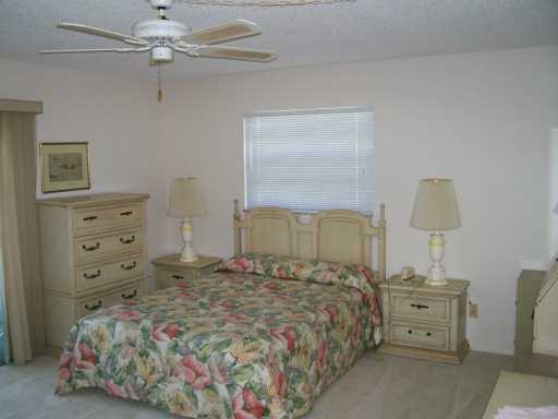 1225 Northwest 21st Street, Unit 3105 Stuart, FL 34994 - Photo 6 of 8 a bedroom with a bed and a dresser