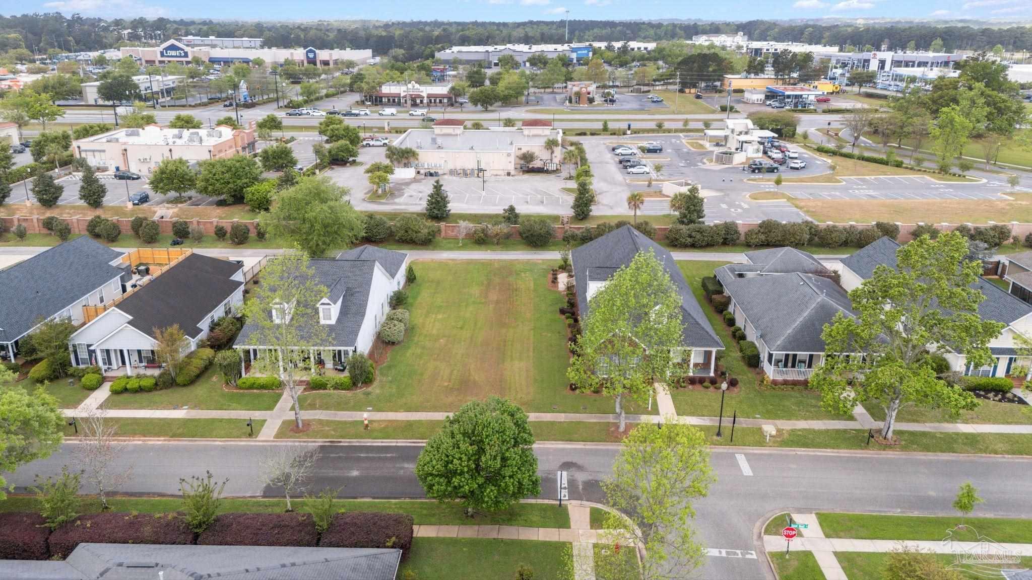 an aerial view of residential houses with outdoor space and swimming pool