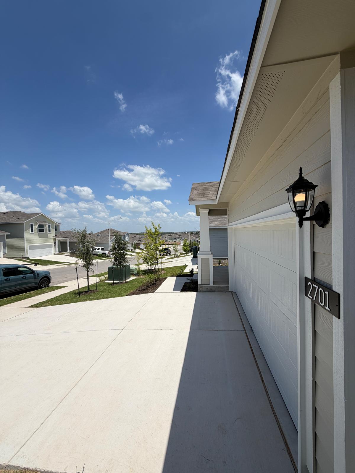 2701 Towy Road Manor, TX 78653 - Photo 5 of 35 A well-maintained concrete driveway leads to a welcoming entry and attached garage.