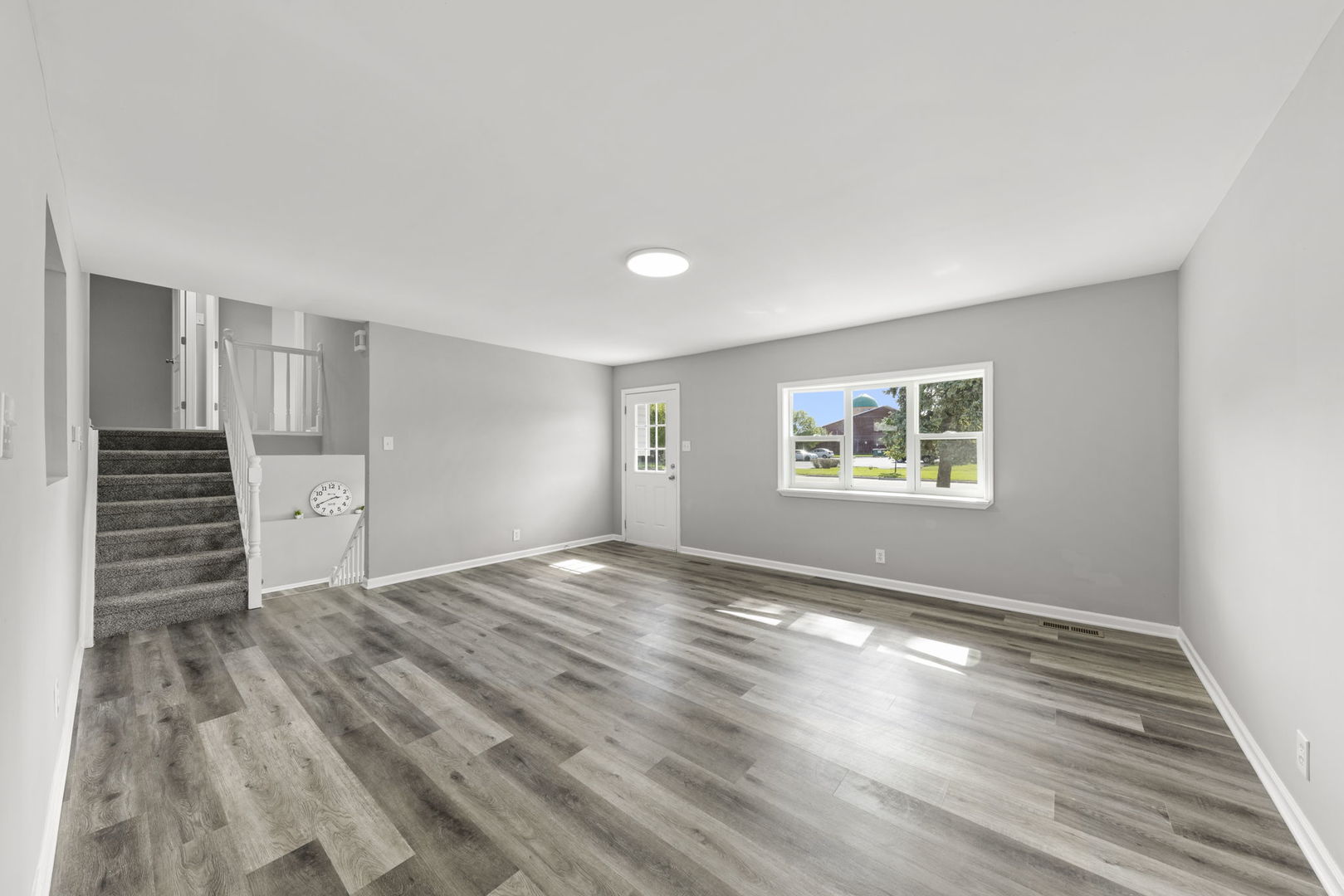 530 East Briarcliff Road Bolingbrook, IL 60440 - Photo 5 of 19 a view of an empty room with a window and wooden floor
