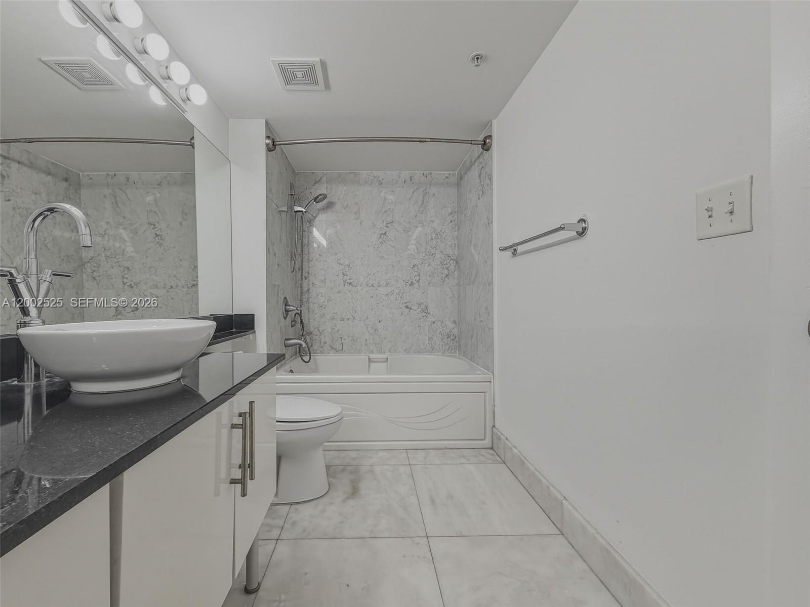 31 Southeast 5th Street, Unit 2301 Miami, FL 33131 - Photo 21 of 50 a bathroom with a sink a toilet and shower