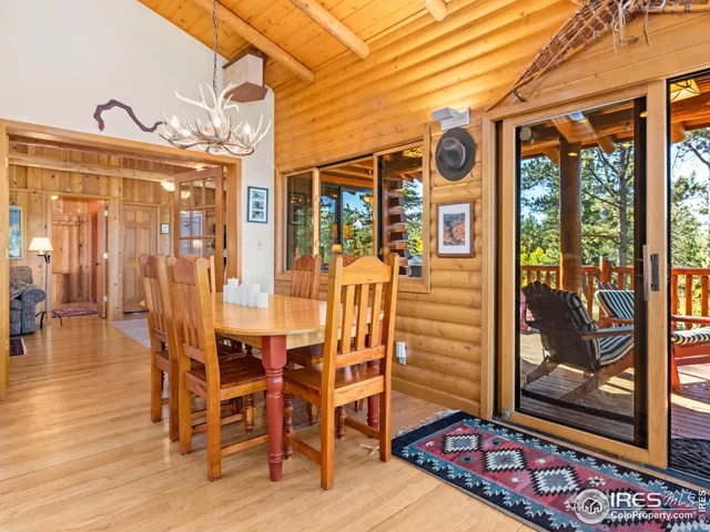 a view of a dining room with furniture wooden floor and painting on the wall