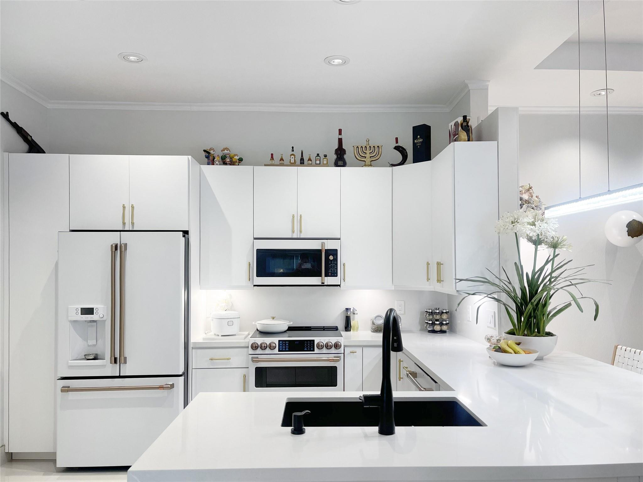 23096 Via Stel Boca Raton, FL 33433 - Photo 8 of 41 a white kitchen with sink a refrigerator and a stove
