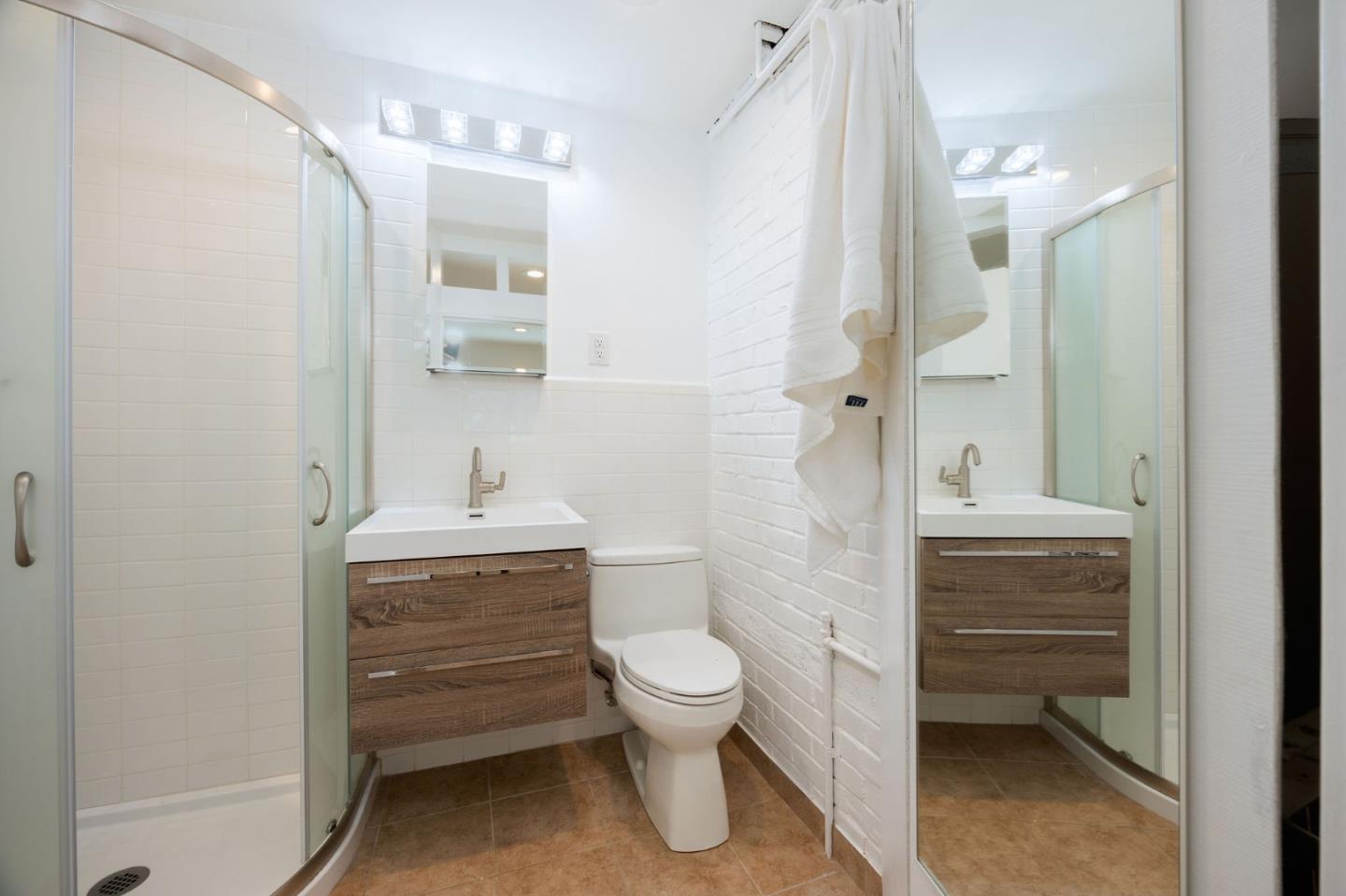 1460 Flores Drive Pacifica, CA 94044 - Photo 28 of 69 a bathroom with a granite countertop sink a toilet and a mirror