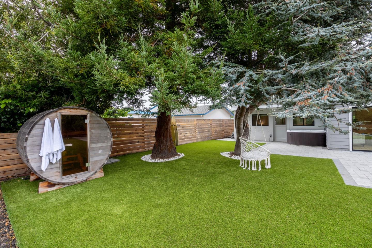 1460 Flores Drive Pacifica, CA 94044 - Photo 57 of 69 a view of a backyard with table and chairs a barbeque and a large tree