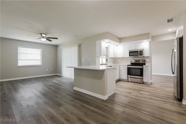 a kitchen with granite countertop a stove top oven and cabinets