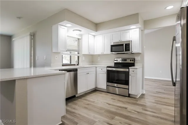 a kitchen with white cabinets and appliances