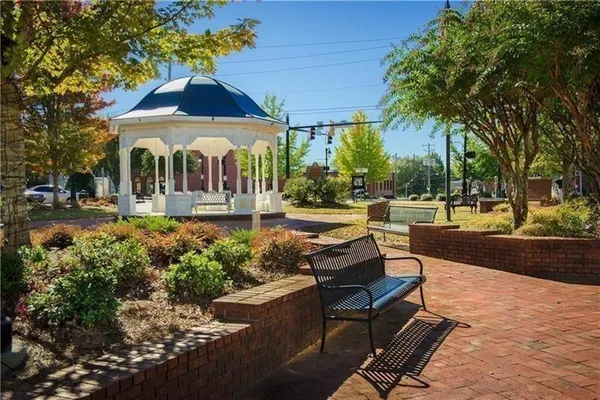 a view of a patio with table and chairs plants and large trees