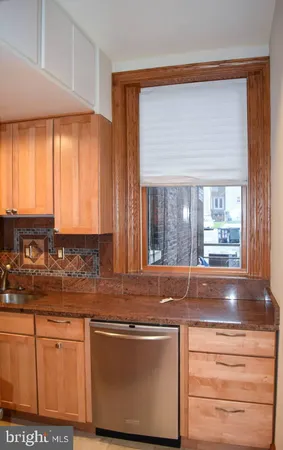 a kitchen with granite countertop cabinets stainless steel appliances a sink and a window